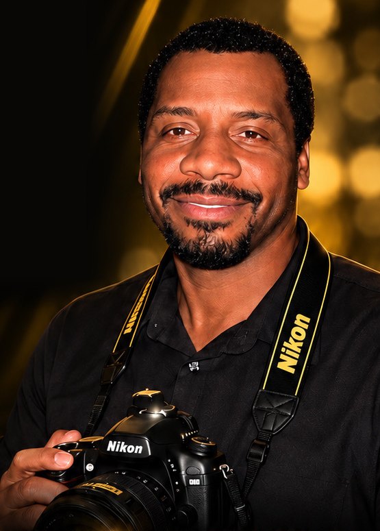Derick Robinson, photographer, holding a Nikon camera
